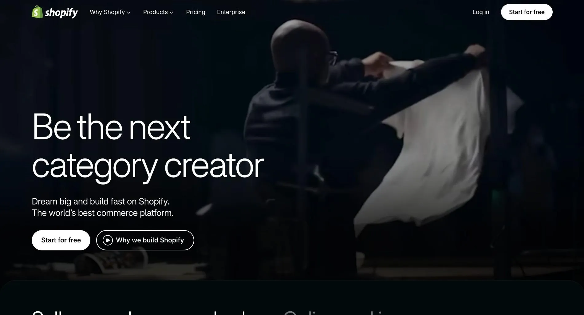 Shopify homepage with the headline "Be the next category creator", a person shaking out a white fabric, and Start for free and Why we build Shopify buttons.
