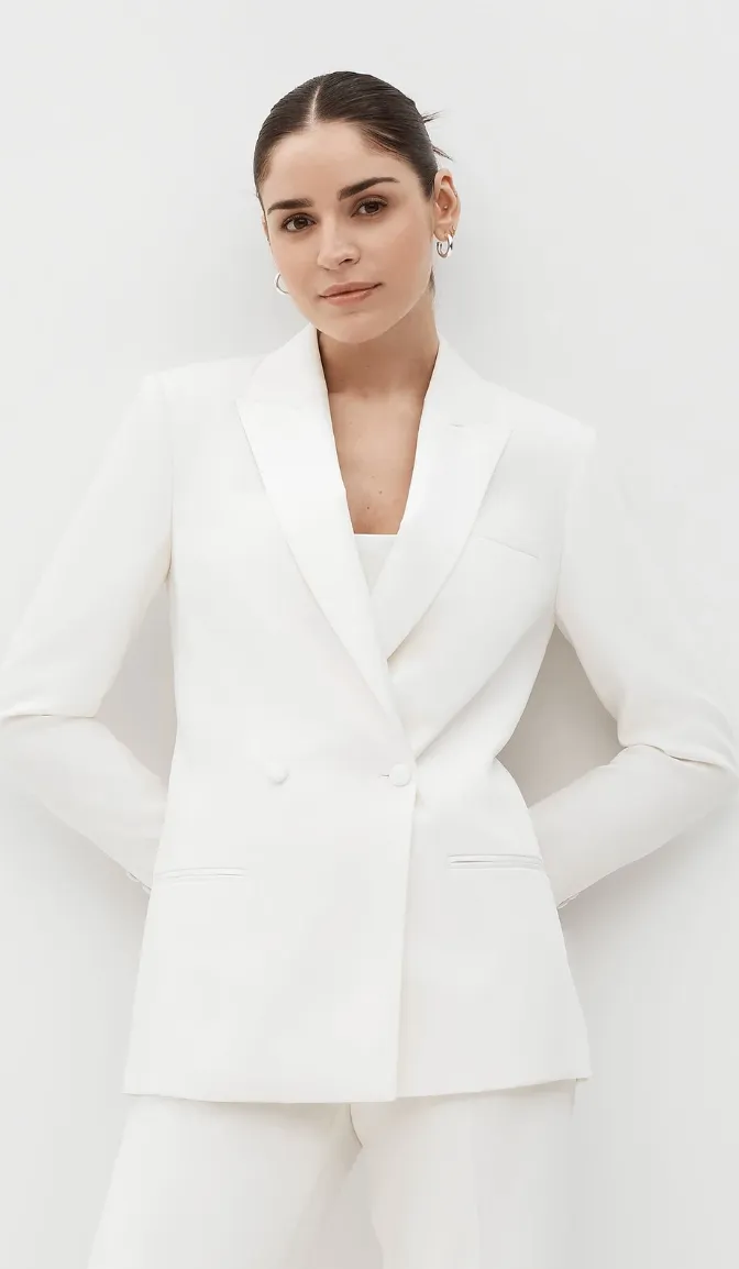 Model in a white double-breasted suit jacket and matching trousers