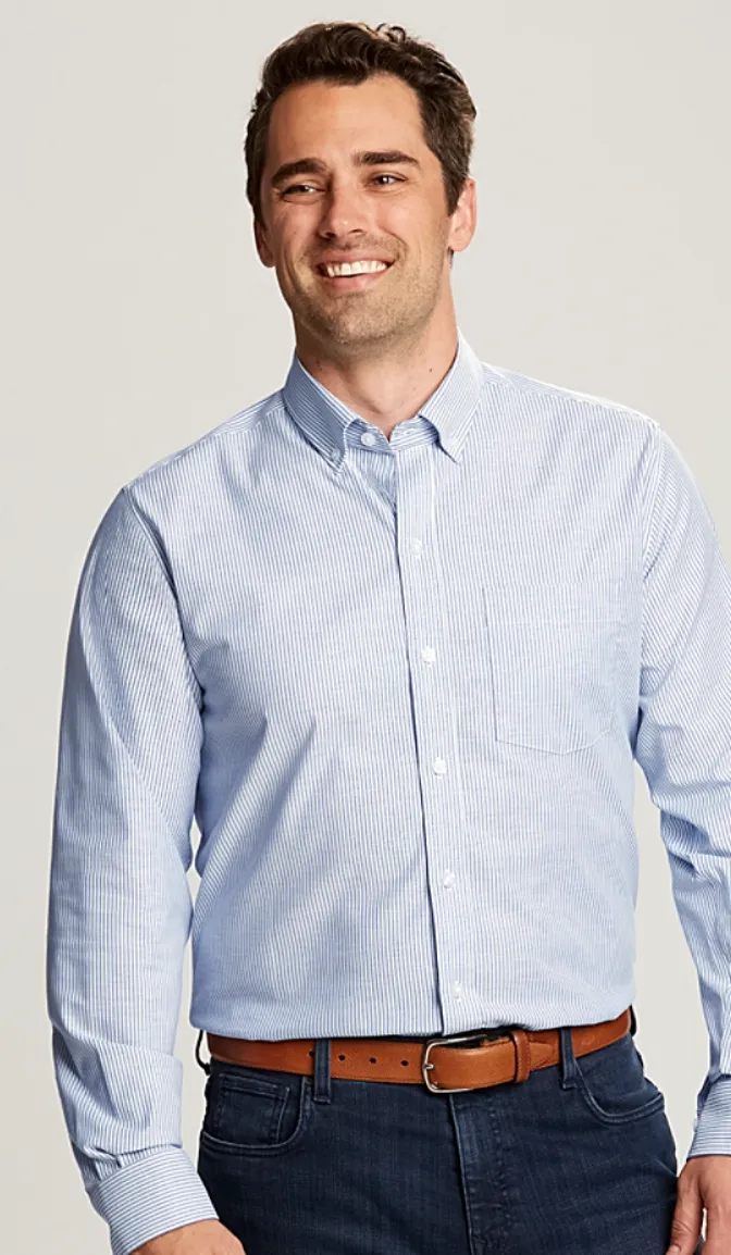 Model in a blue striped button-down shirt, brown belt, and dark jeans