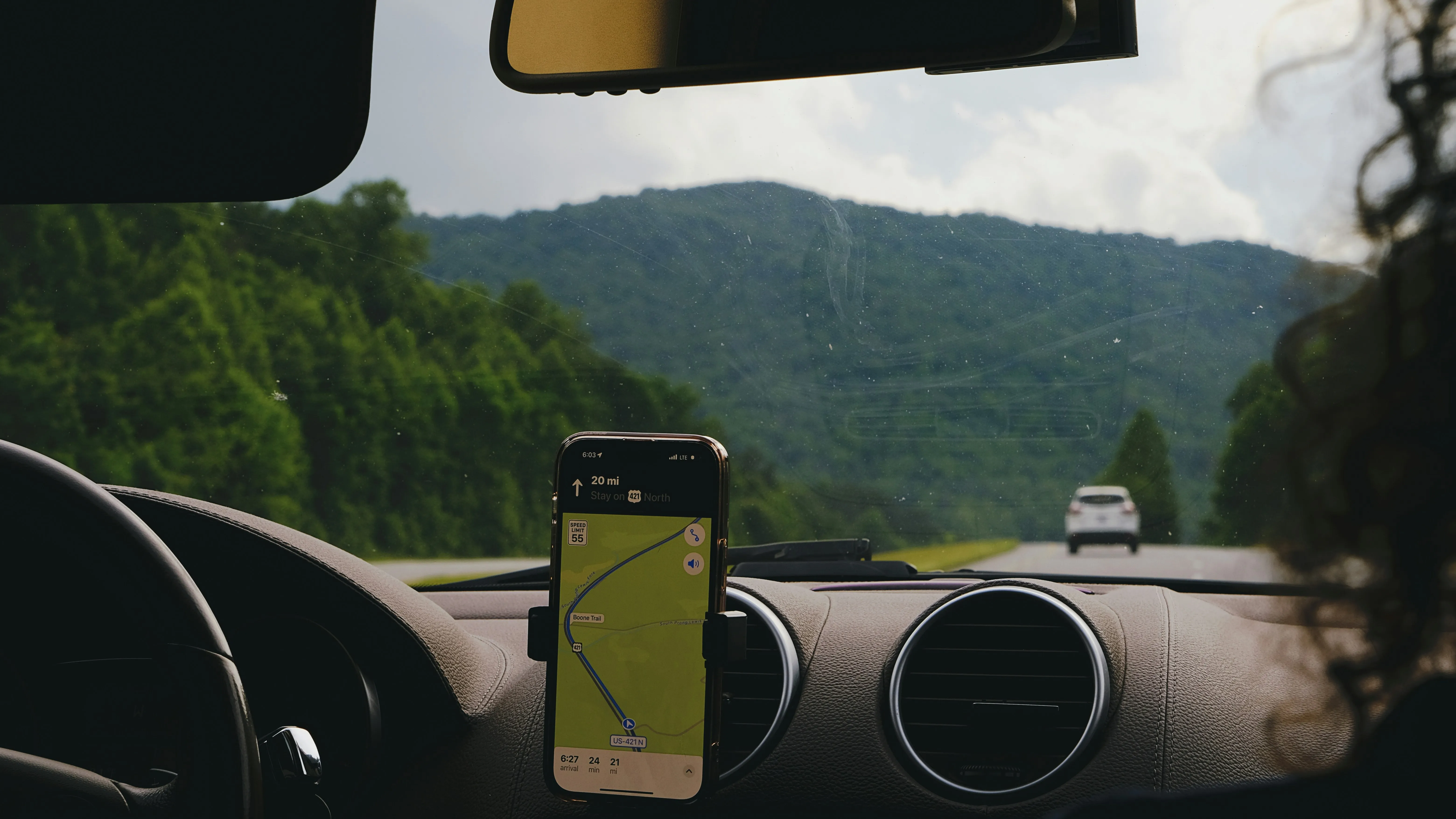 Phone in a dashboard mount showing map directions on a mountain road