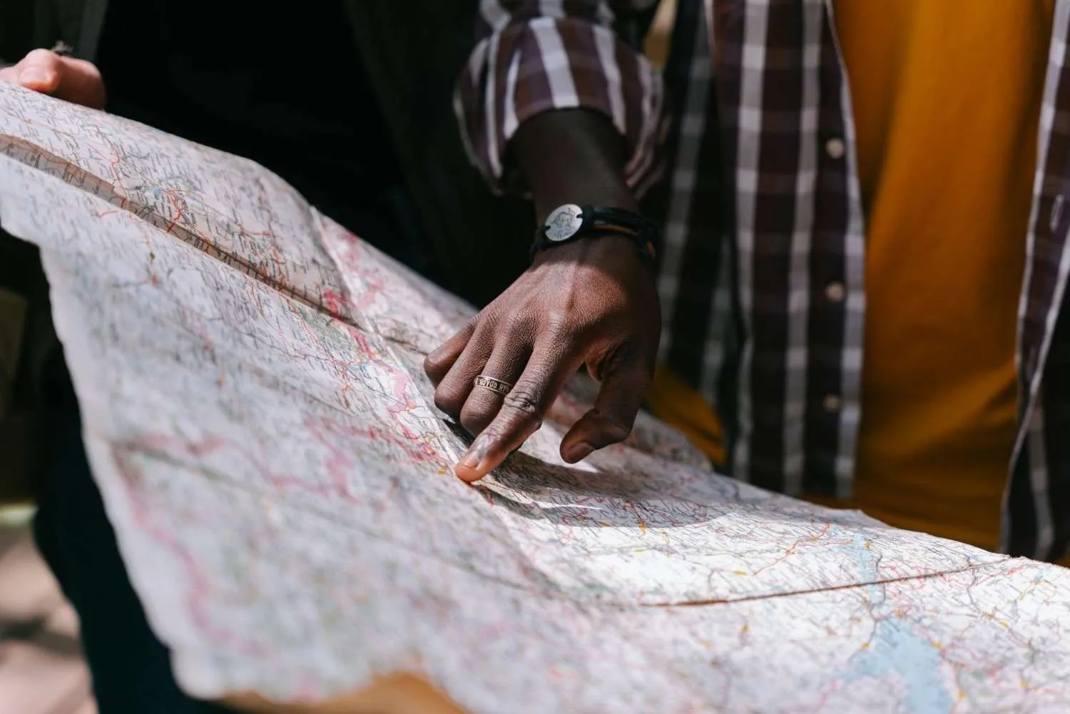Hand pointing to a spot on a large paper road map