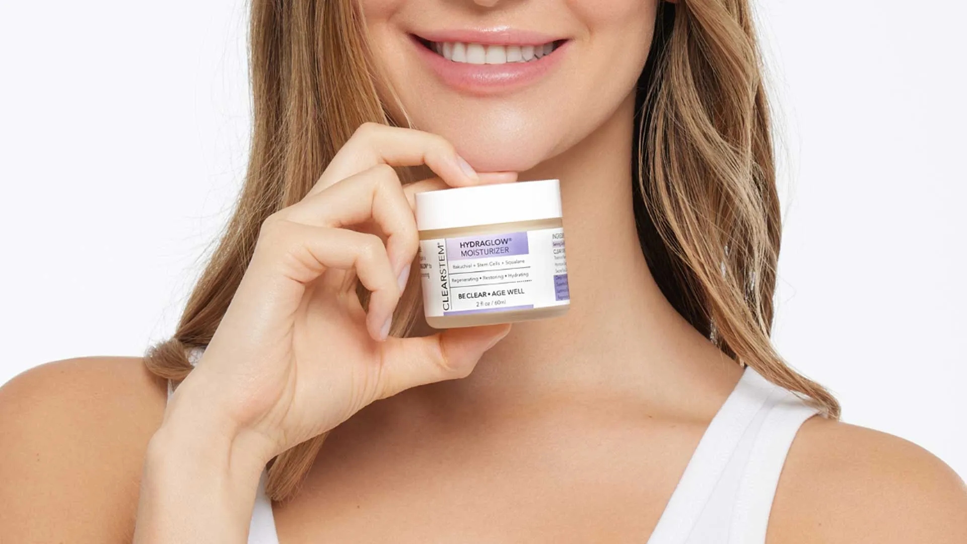 Woman smiling while holding a jar of Clearstem Hydraglow moisturizer