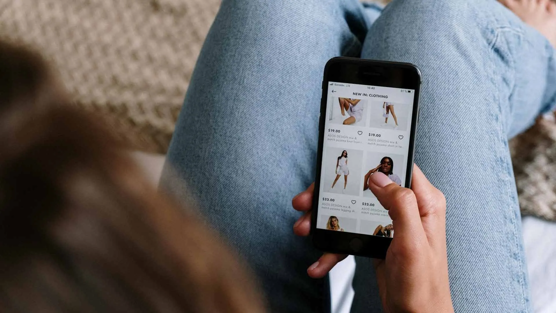 Person browsing clothing product listings on a phone