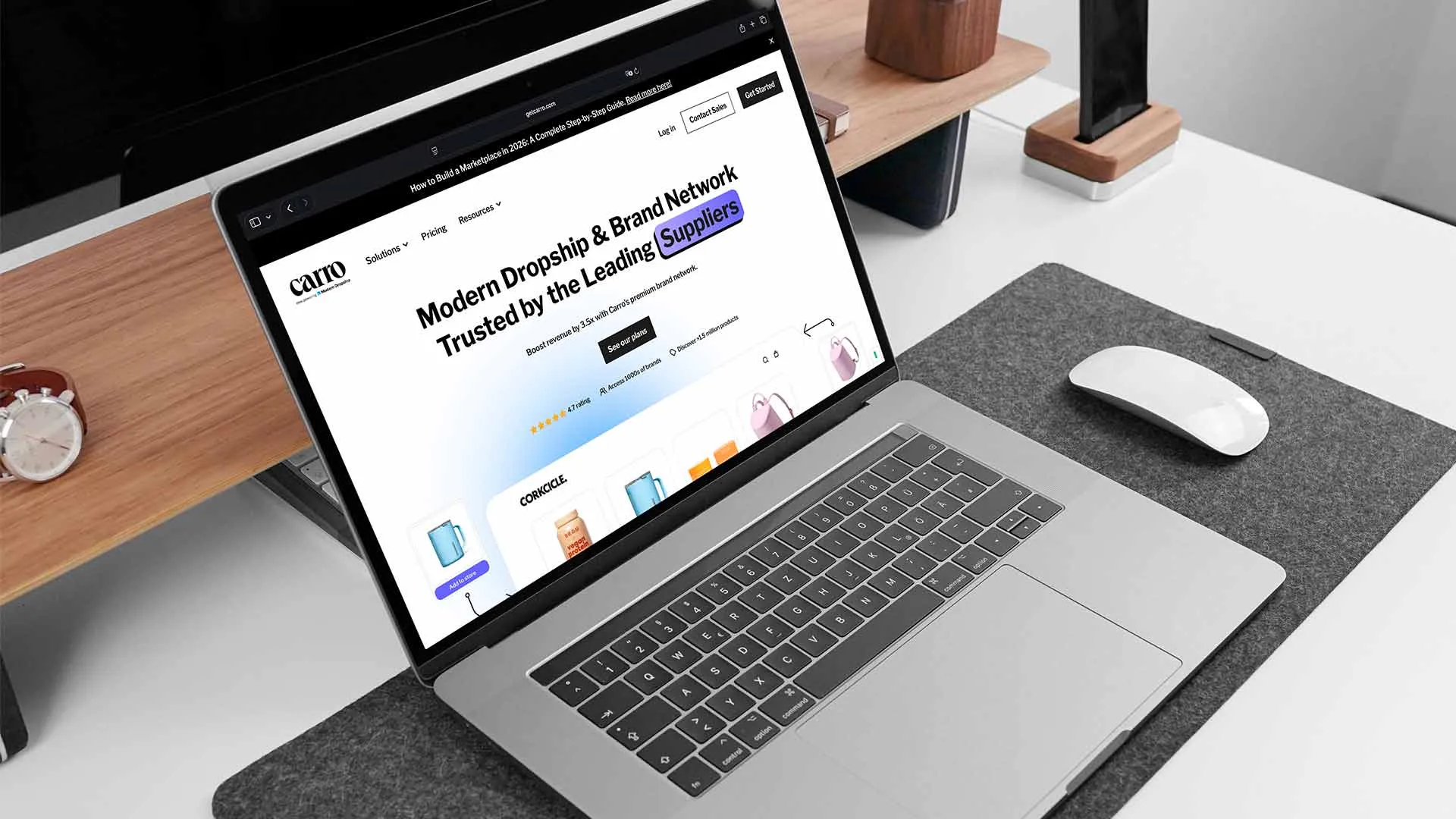 Laptop on a desk showing the Carro homepage with Corkcicle products